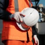 Mineri cerrando la mano, sujetando un casco de seguridad