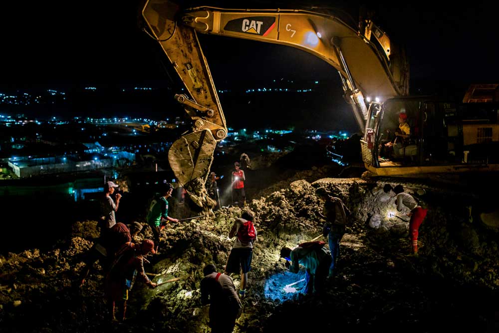Mineros buscando jade en un montón de escombros