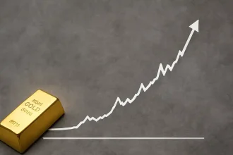 Barra de oro brillante sobre una superficie gris con un gráfico de línea blanca ascendente que representa el aumento histórico en el precio del oro.
